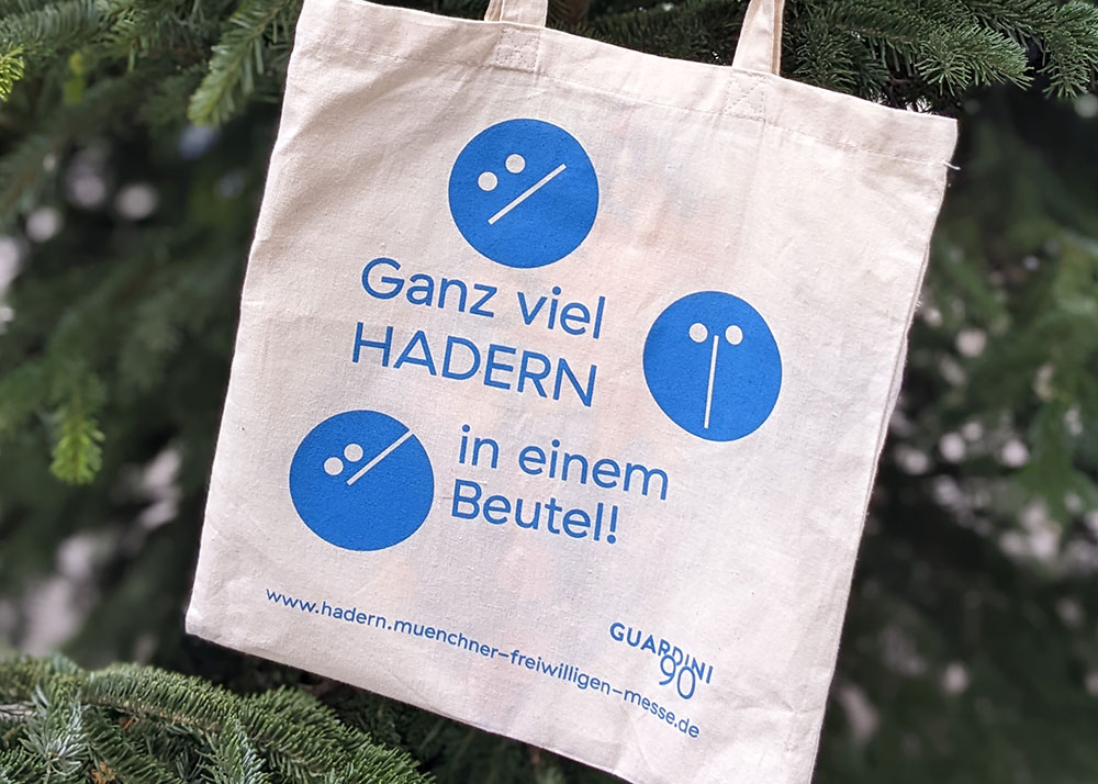 Eine Stofftasche mit Kreisen und der Aufschrift "ganz viel Hadern in einem Beutel" und dem Logo von Guardini90